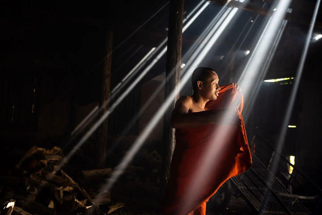 A Buddhist monk illuminated by shafts of light