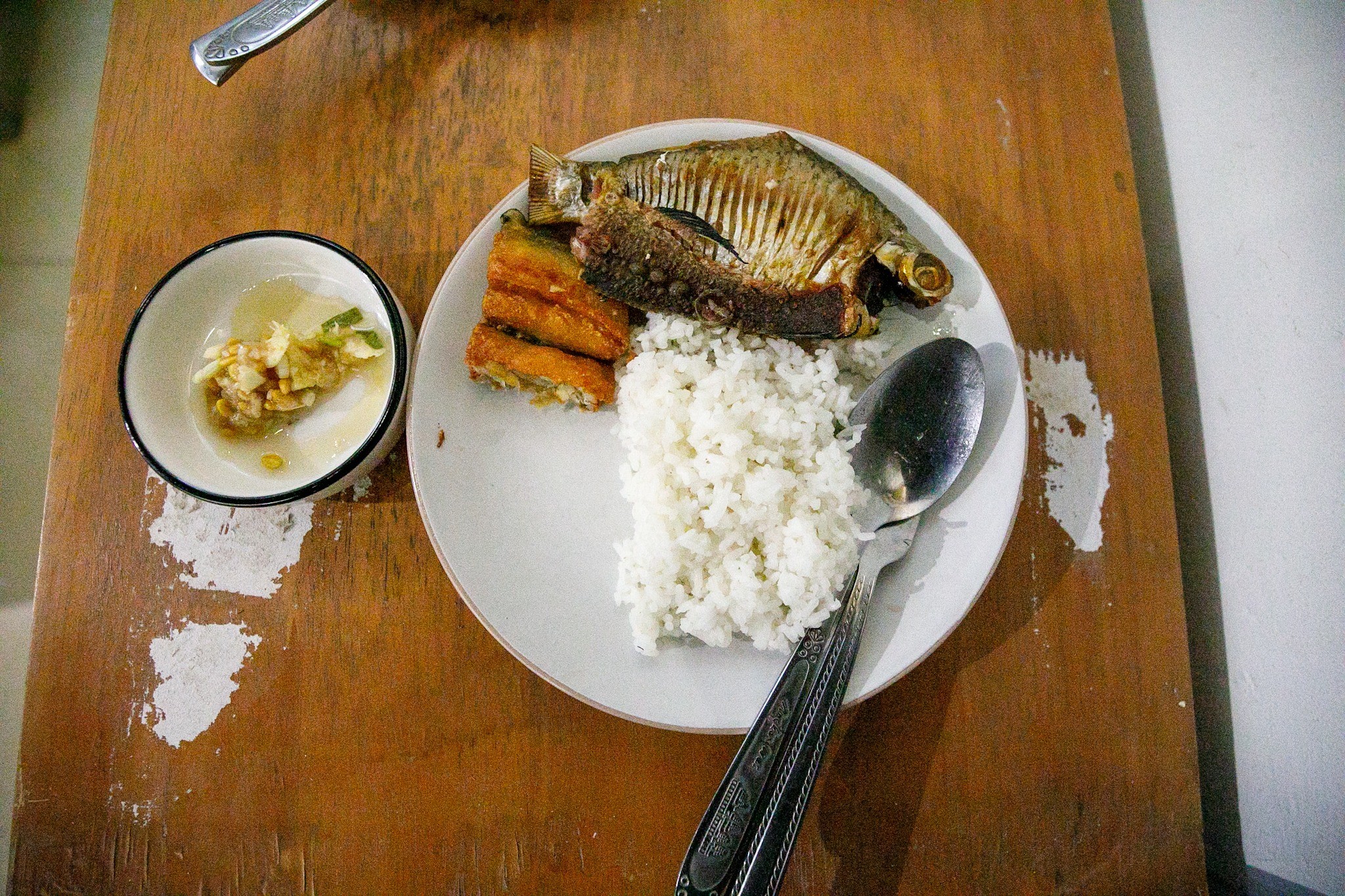 Lunch of rice, fish and vegetables on a wooden table
